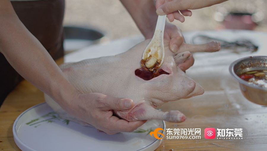 1664421244462381.jpg 将腌制酱料填满鹅坯肚中.jpg