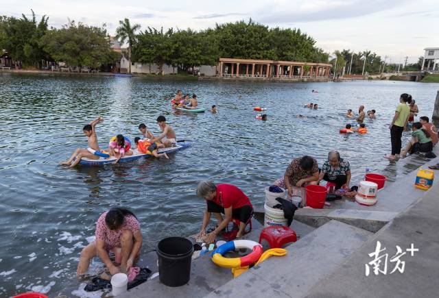 6月22日，汕头潮阳区铜盂镇，傍晚的练江支流边，妇女们在洗衣物，孩子则在水中玩耍。