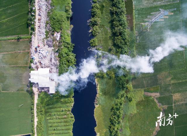 2015年，汕头潮南区司马浦镇，练江支流边的工厂正冒出大量白烟。
